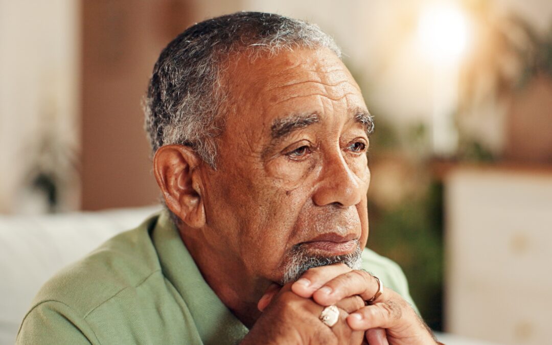 Man looking sad, pensive, resting his head on his hands